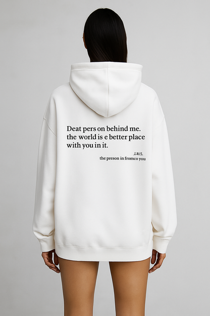 White hoodie with a motivational quote on the back, worn by a person against a gray background